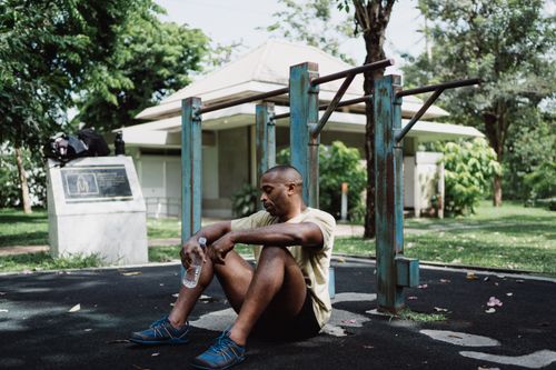 A man taking a relaxed pause outdoors after exercise