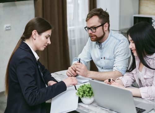 A couple discussing paperwork with an advisor